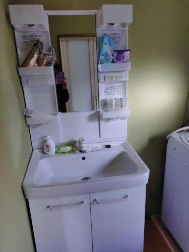 a bathroom with a white sink and a mirror at itoshima 個性的な日本家屋 in Itoshima