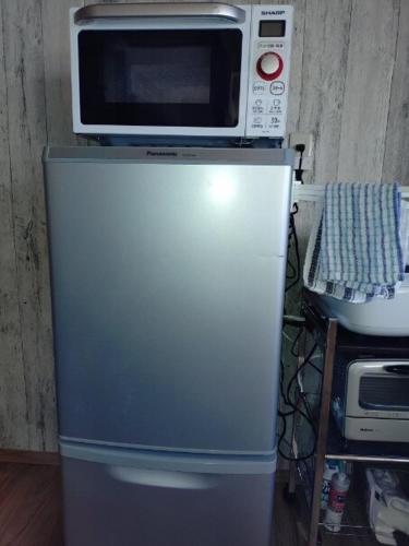 a microwave sitting on top of a refrigerator at itoshima 個性的な日本家屋 in Itoshima