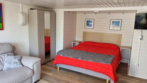 - une chambre avec un lit rouge et un canapé dans l'établissement Villa MIRENSOU, à Montfort-en-Chalosse
