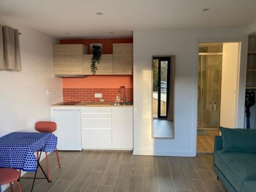 une cuisine et un salon avec une table et un canapé dans l'établissement Studio Cosy St Martin Uriage, à Saint-Martin-d'Uriage