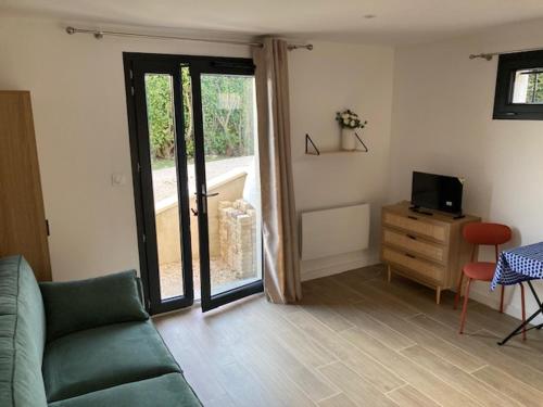 un salon avec un canapé et une télévision dans l'établissement Studio Cosy St Martin Uriage, à Saint-Martin-d'Uriage