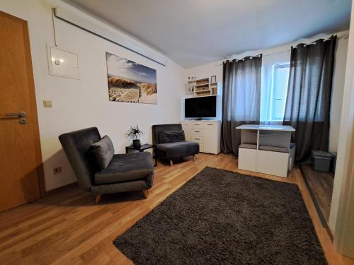 Una sala de estar con una silla y un televisor. en Cosy Retreat in Friolzheim, en Friolzheim