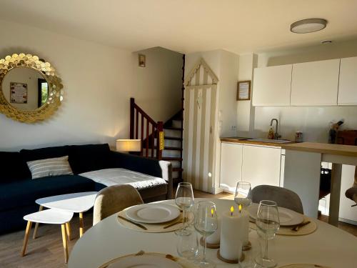 滨海布隆维尔Le Cottage D'Ilona的客厅里有一张桌子和一张沙发