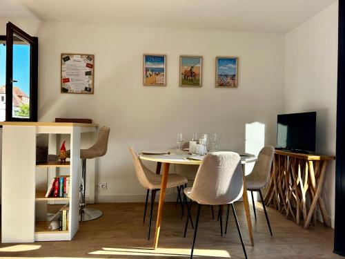 une salle à manger avec une table et des chaises et une télévision dans l'établissement Le Cottage D'Ilona, à Blonville-sur-Mer