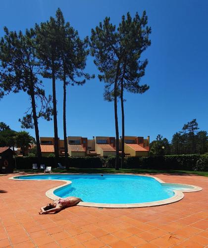 a woman laying on the ground next to a swimming pool at Big Fish 1 - Charming Beach Apartment in Praia de Mira