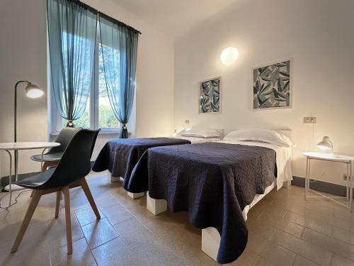 a bedroom with two beds and a table at Hotel Meublè Agavi in Monterosso al Mare