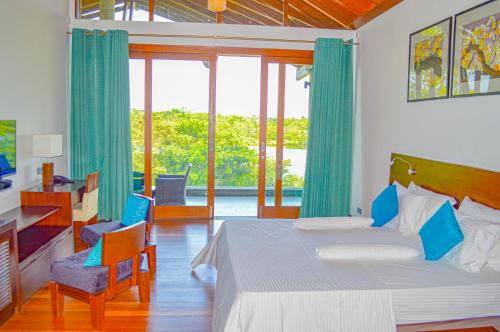 a bedroom with a bed and a large window at Watergate Bolgoda Hotel in Bandaragama