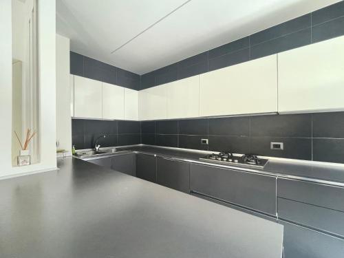 a kitchen with white cabinets and a stainless steel counter at CASA AL FARO - Anzio Centro in Anzio