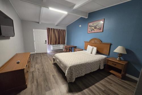 una camera d'albergo con un letto e una televisione di Luxury Inn & Suites a Nacogdoches