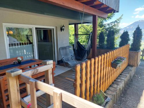 a wooden deck with a hammock on a house at Huber's Lodge in Hainzenberg