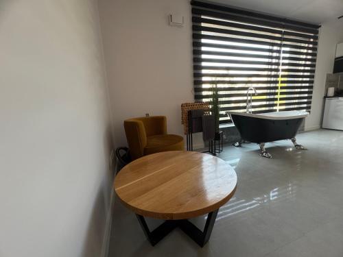 a room with a table and a tub in a room at New Apart Smart- OAZA RELAKSU-Rynek Central Kielce - Parking -fak VAT- rok budowy 2025 in Kielce