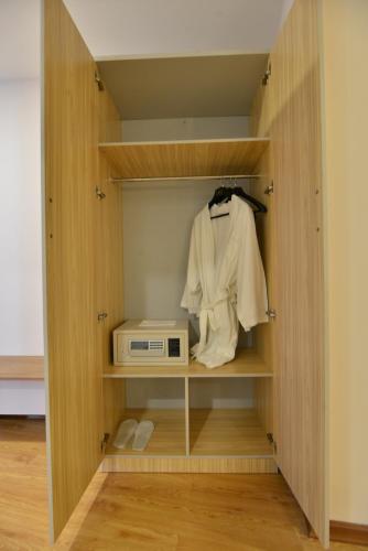 a closet with a microwave and a shirt in it at Serene Valley Hotel in Yangon