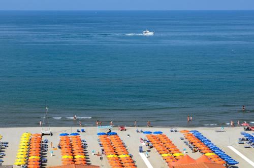 
a beach filled with lots of beach chairs and umbrellas at Grand Hotel Royal in Viareggio
