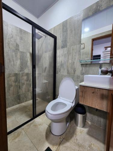 a bathroom with a toilet and a shower and a sink at Hotel tranquilandia La 14 in La Dorada