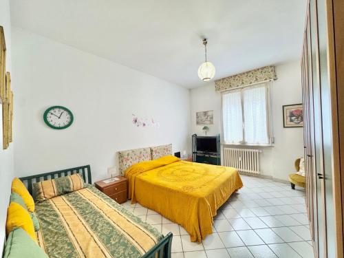 Un dormitorio con dos camas y un reloj en la pared. en Appartamento Pessola, en Parma