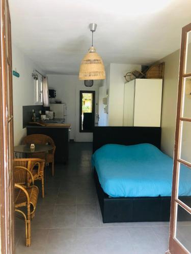 - une chambre avec un lit bleu et une table dans l'établissement Studio avec jardin proche plages saint clair Lavandou, au Lavandou