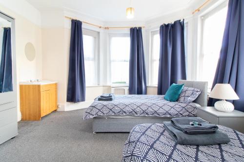 a bedroom with two beds and blue curtains at Thornbury Guest House Room 5 in Southampton