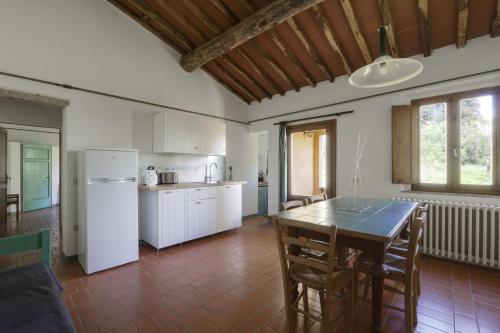 a kitchen and dining room with a table and refrigerator at Agriturismo La Ca'Solare in Palaia