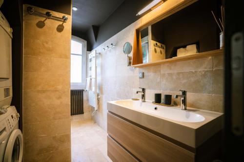 une salle de bain avec un lavabo et une douche dans l'établissement L'Aneto - Charme Balcon Home-cinema, à Paris