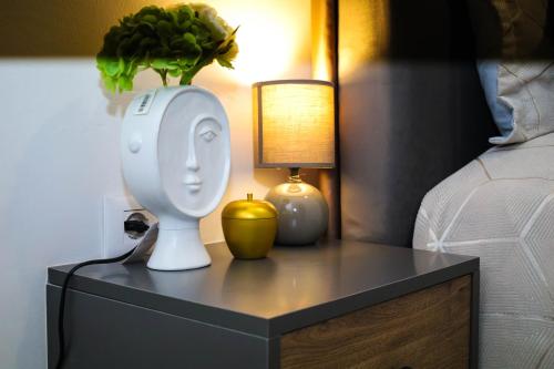 a bedside table with a lamp and a vase on it at Tritea Apartments in Golem