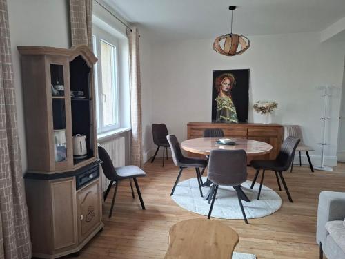 - un salon avec une table, des chaises et un tableau dans l'établissement Sedan, ville d histoire, à Sedan