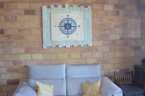 eine Ziegelwand mit einem Bild über einem Sofa in der Unterkunft Els Vents primera línea playa Puçol in Playa de Mar