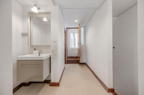 un bagno bianco con lavandino e specchio di Moondance House Chinatown a Bangkok