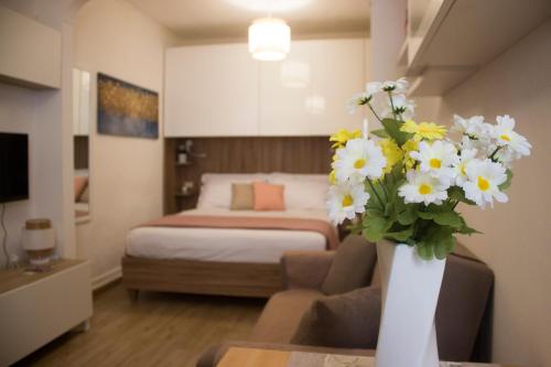 a room with a bed and a vase of flowers at Casa vacanze Perla Marina in Alghero