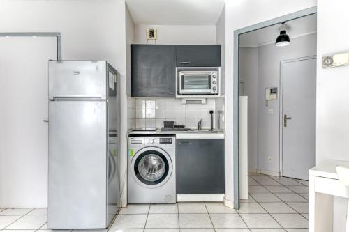 une cuisine avec un réfrigérateur et une machine à laver dans l'établissement GuestReady - Comfort & Charm in Lyon’s Heart, à Lyon