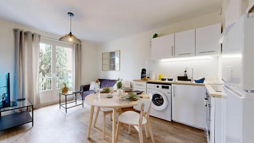 Il comprend une cuisine et une salle à manger avec une table et un lave-linge. dans l'établissement expat renting - Le Pastel - Netflix - Zenith, à Toulouse