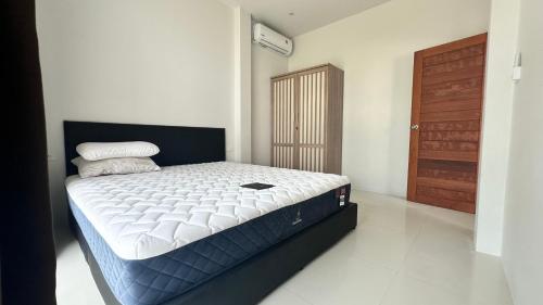 Un dormitorio con una cama grande en una habitación. en Cha-emHouse1 Baantai, en Thong Sala