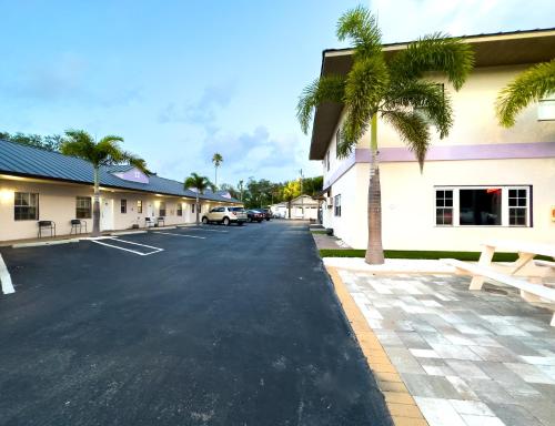 a parking lot in front of a building with palm trees at Stylish 1b1b Unit With Kitchen And Pool in Clearwater