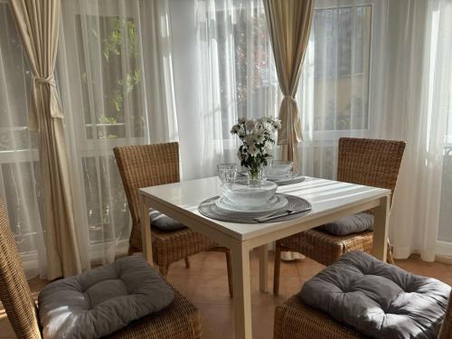 a white table with chairs and a vase of flowers on it at Atia Resort in Chernomorets