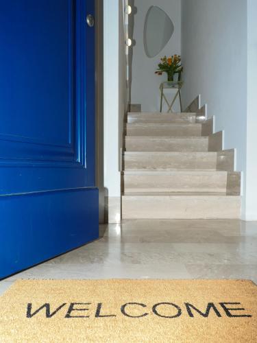 a welcome mat in front of a blue door and stairs at CASA di LU in Civitanova Marche