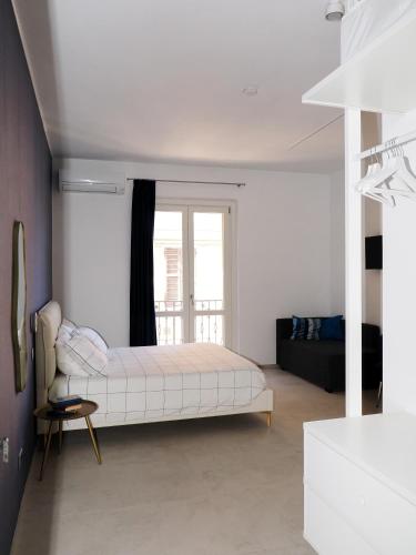 a white bedroom with a bed and a window at CASA di LU in Civitanova Marche