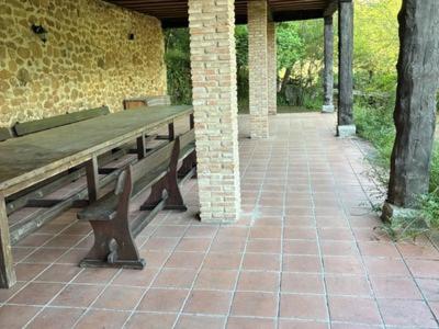 a wooden bench sitting on a brick patio at CASA RURAL EL RONDILLO in Navaconcejo