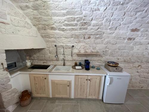 a kitchen with a sink and a white brick wall at L'arco dei sogni in Ceglie Messapica