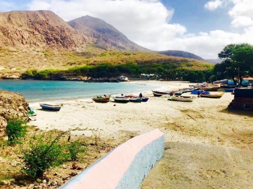 a group of boats sitting on a sandy beach at La Kaza du Soleil in Tarrafal
