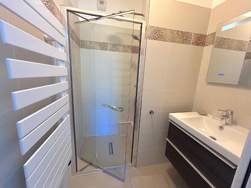 une salle de bain avec douche et lavabo dans l'établissement L'appartement Saussure, à Paris