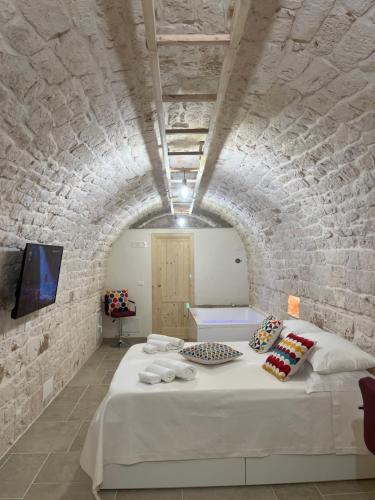 a bedroom with a bed in a brick wall at L'arco dei sogni in Ceglie Messapica