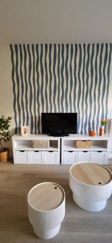 - un salon avec 2 tables blanches et une télévision dans l'établissement Escale en Méditerranée, swimmingpool, terrace,AC, à Antibes