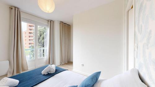 une chambre avec un lit et une grande fenêtre dans l'établissement expat renting - Le Pastel - Netflix - Zenith, à Toulouse
