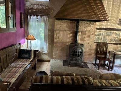 a living room with a fireplace and a couch and a stove at CASA RURAL EL RONDILLO in Navaconcejo