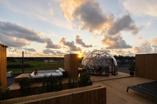 a gazebo on a patio with a sunset at Seaside Stay in Palanga