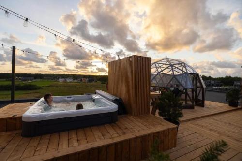 a man in a hot tub on a deck at Seaside Stay in Palanga