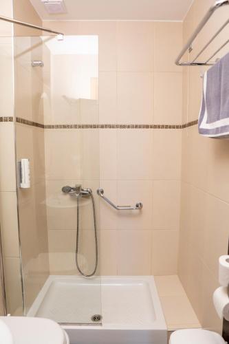 a bathroom with a shower with a tub and a toilet at Hotel Epavlis Eleftheriadi in Paralia Katerinis