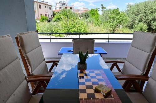 a table and chairs on a balcony with a chessboard at Magdalena Cozy Apartment in Sparti