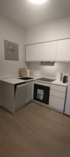 a kitchen with white counters and white cabinets at Ariminum Suite - Minimalism and class in the historic center in Rimini