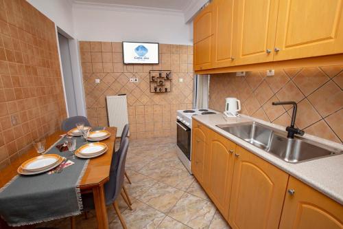a small kitchen with a table and a sink at Calm Sea in Lávrion