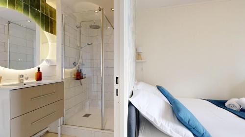 une salle de bain avec une douche, un lit et un lavabo dans l'établissement expat renting - Le Pastel - Netflix - Zenith, à Toulouse